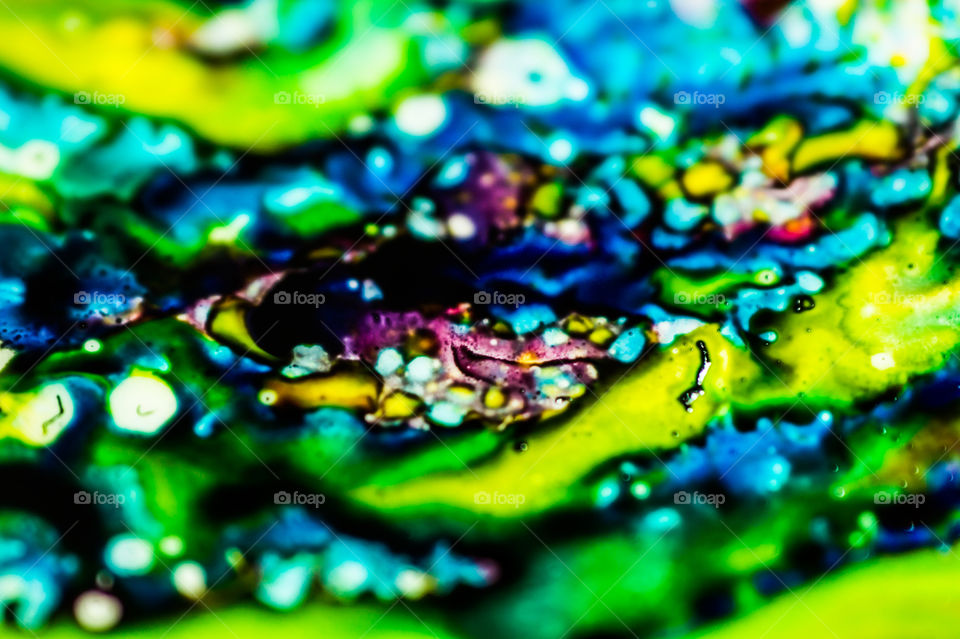 The ink to refill the printer cartridge was spilled onto the white washbasin and the paints blended into abstract drips and patterns.