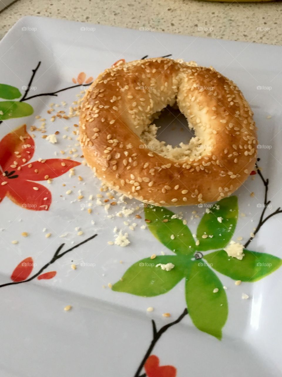 Montreal style sesame seed bagel on floral plate