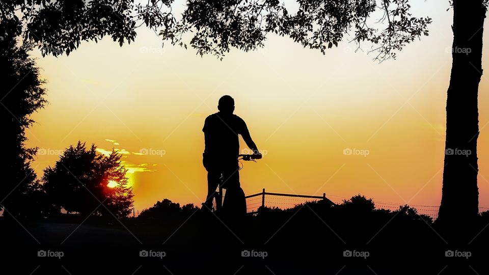 Man Riding a Bike at Sunset in Summer