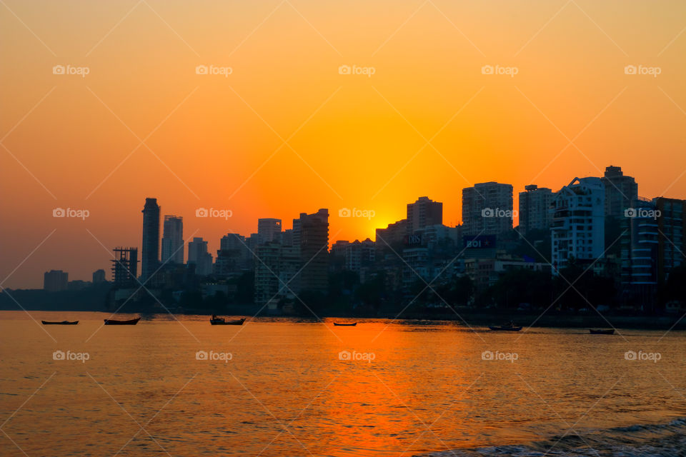 sunrises behind the sky scrappers in the city by the sea