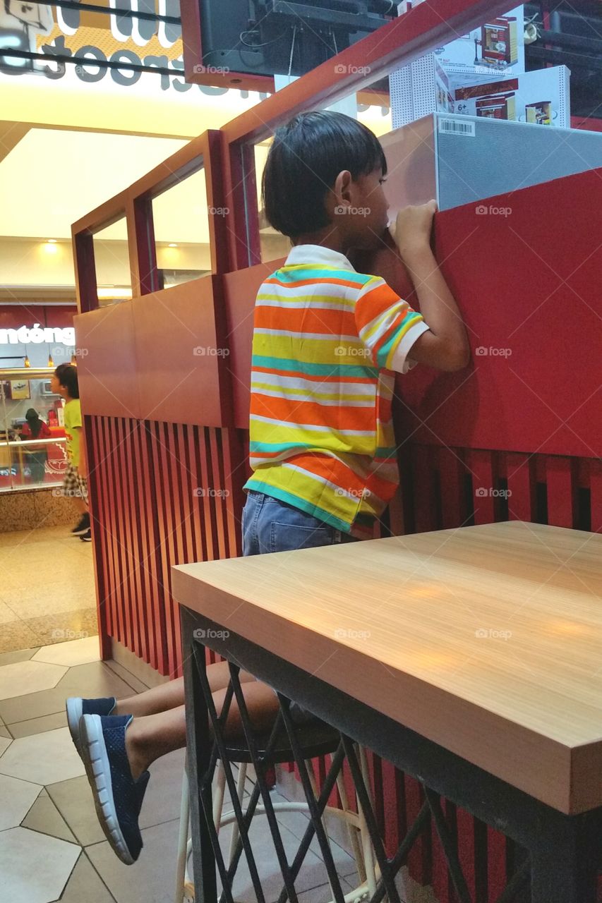A boy was waiting for his order at a restaurant. Photo was taken at 2019 in Jakarta Indonesia.