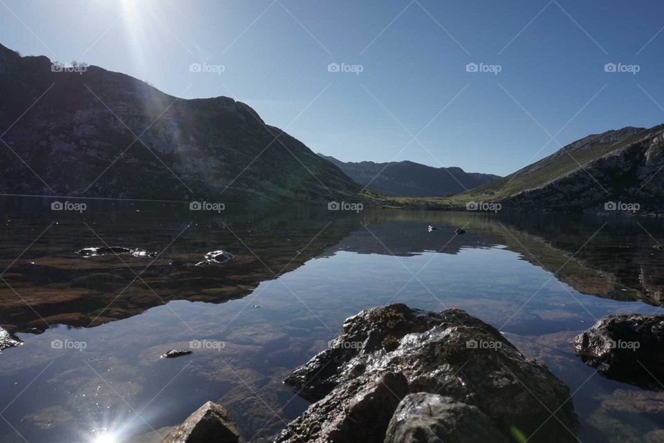 Mountains#lake#rocks#sun#rays#reflect