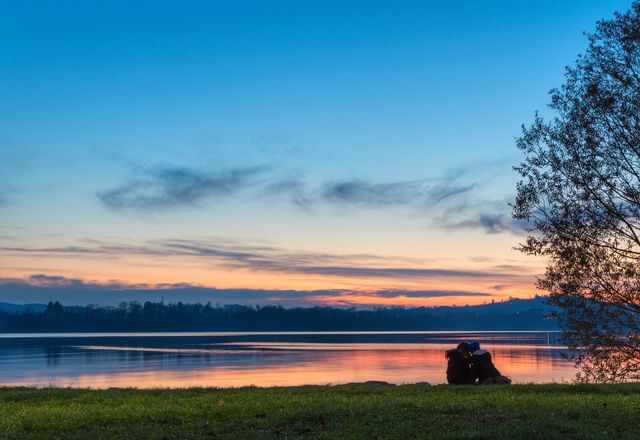Boyfriends in love embraced on the lake shore at sunset in a natural park