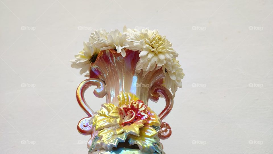 Beautiful white flowers in a colourful flowerpot with a flower sculpture, Flowers in a vase, colourful vase, white flowers in a vase