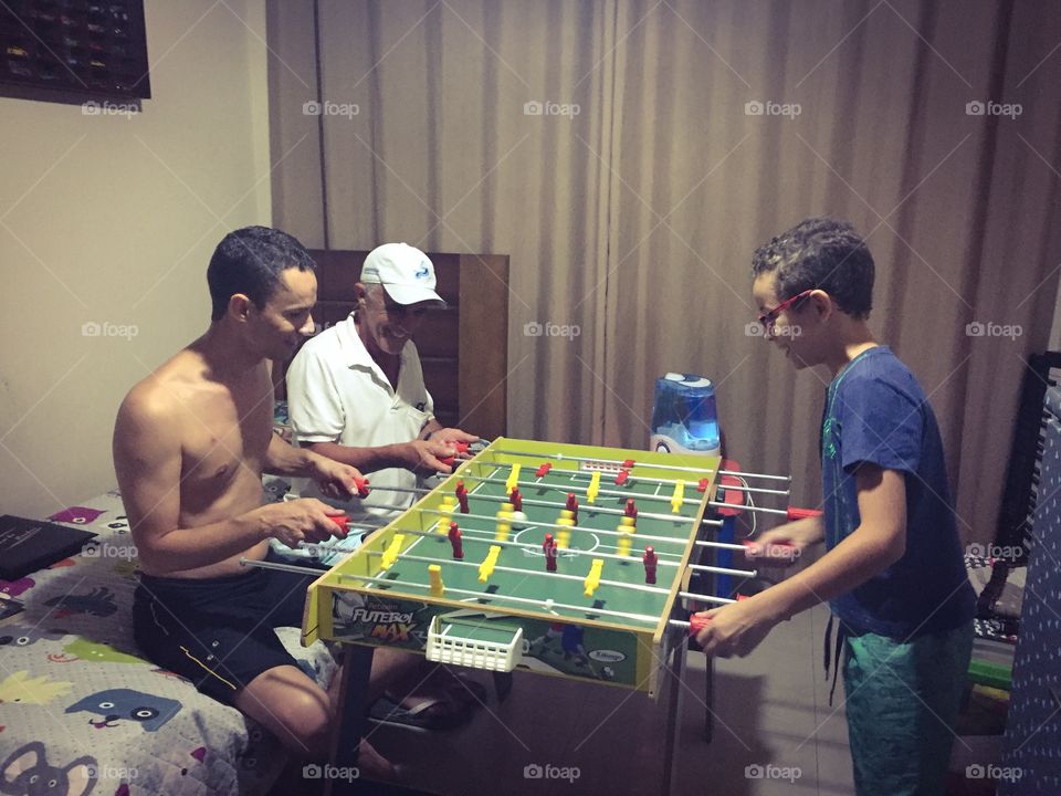 Grandfather and grandson playing indoor soccer football