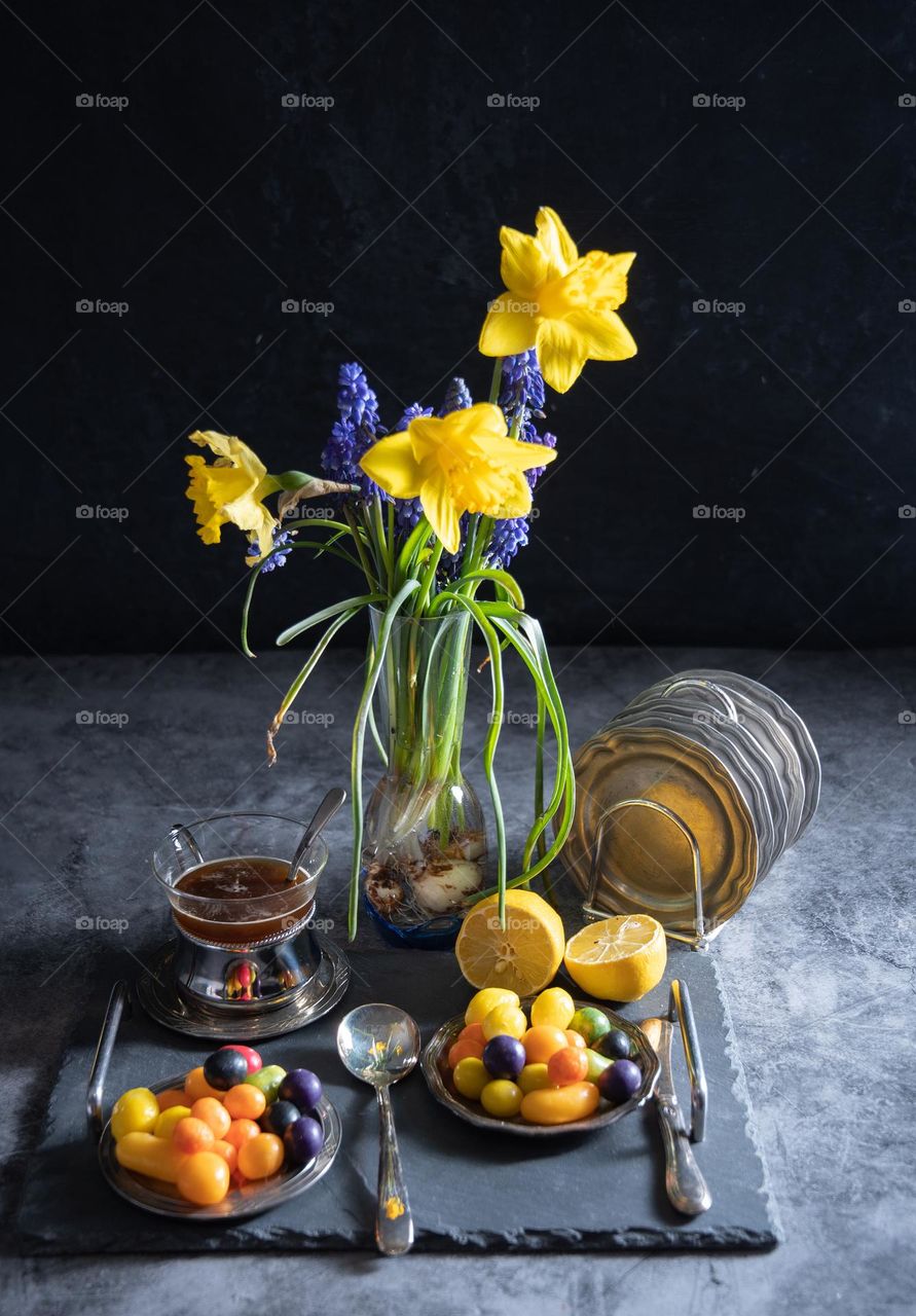 Spring still life with yellow daffodils and blue muscari in a vase on the table sandwiches on a plate, colorful candy, easter theme, colorful food, sweet homemade breakfast, brunch, delicious food