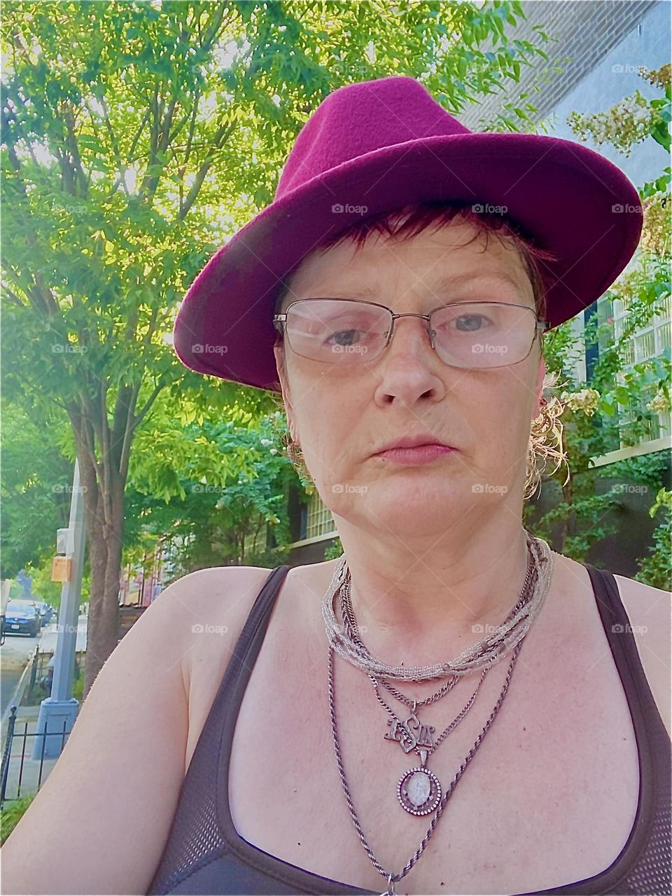 A beautiful portrait photograph taken on a summer day in 2022 while walking back to “Salvation” from the “Pulaski Bridge”. The weather is ideal for wearing a revealing top and of course the customary Fedora hat. 2022. Hypnotic Productions