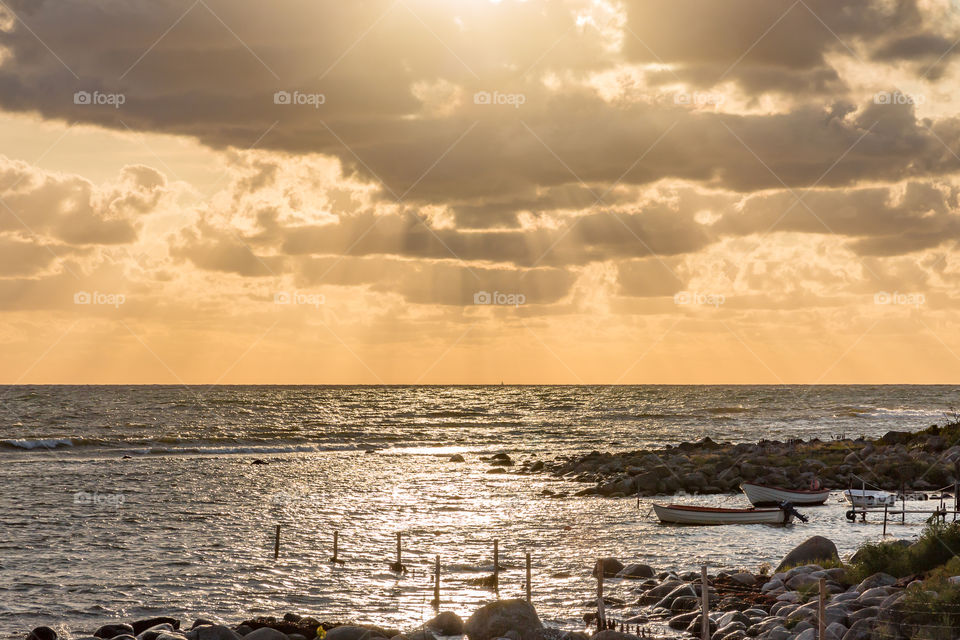 Sun shining through the clouds, reflection in the ocean 