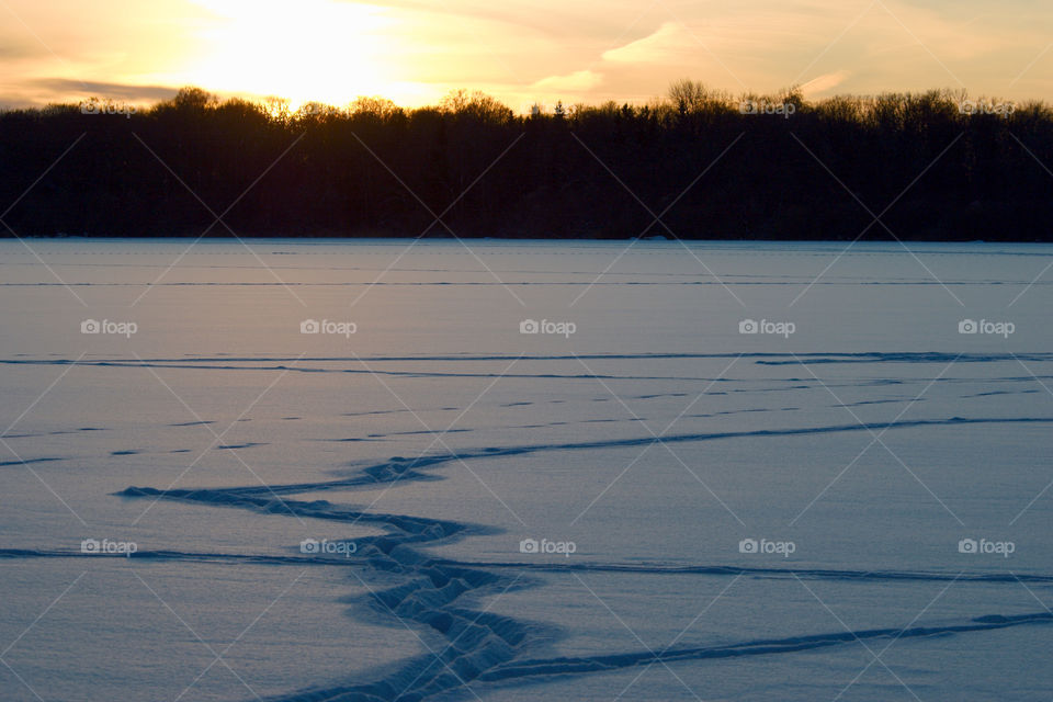 Sunset over a frozen lake in winter.