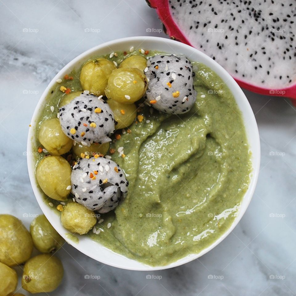 Healthy Green smoothie bowl with gooseberries and dragon fruit 