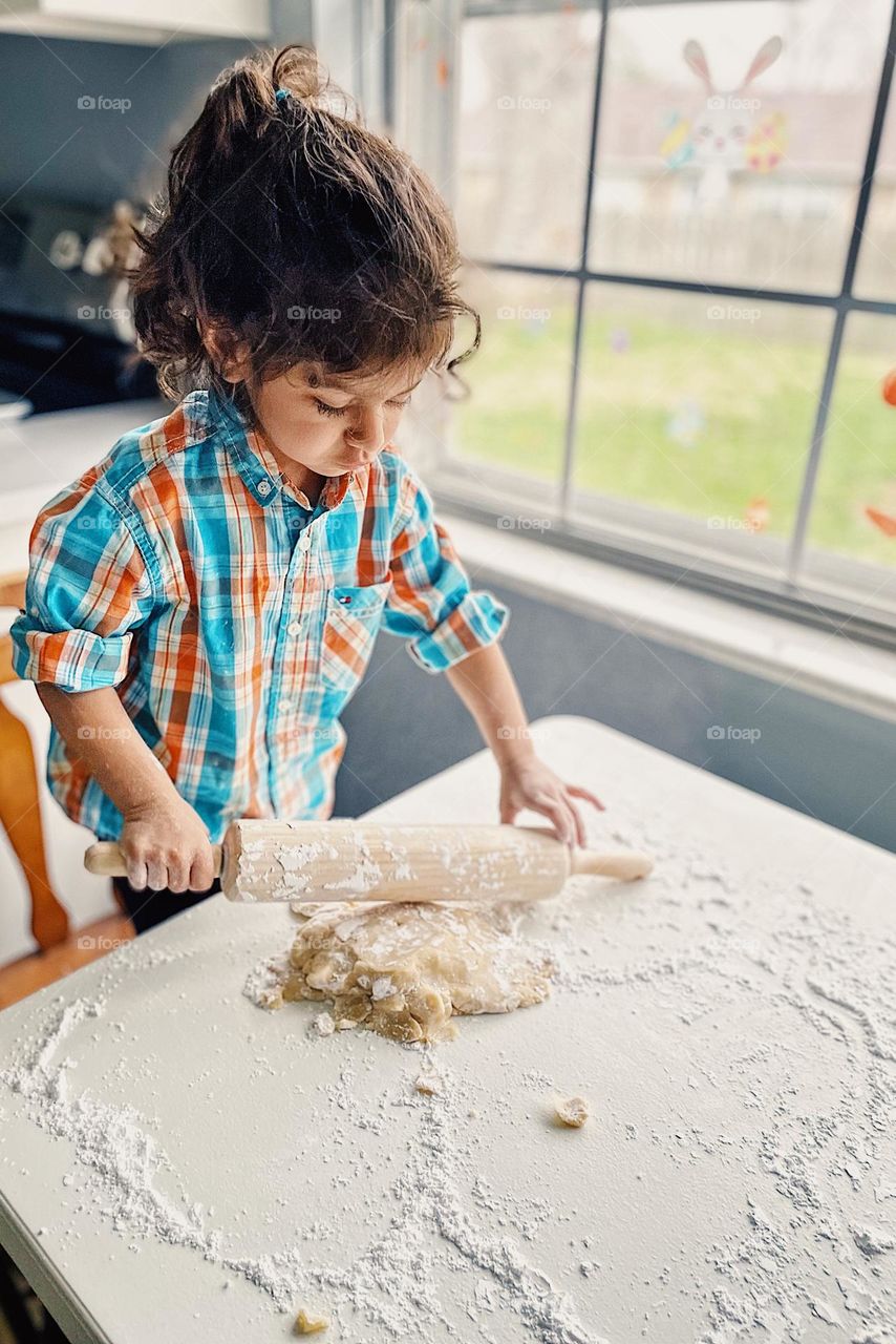 Toddler rolling out cookie dough to make sugar cookies, toddler helping mommy, making cookies with children, homemade cookies, toddler concentrating on task at hand, making cookies with kids, baking at home for the holidays 