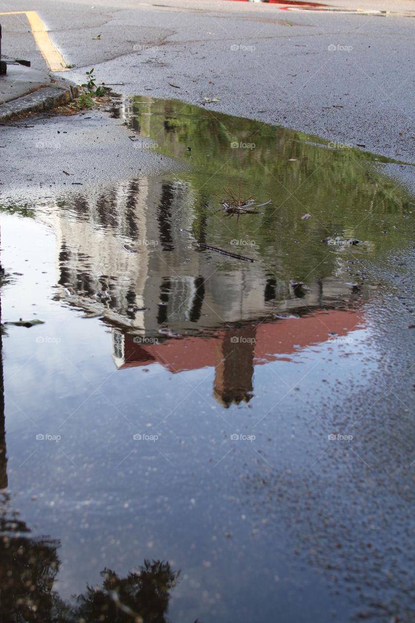 Puddle reflection of old house