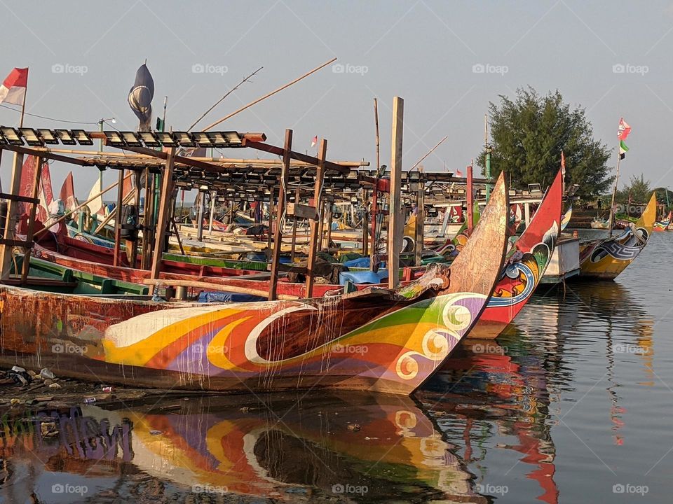 Traditional fishing boats are leaning on a small pier