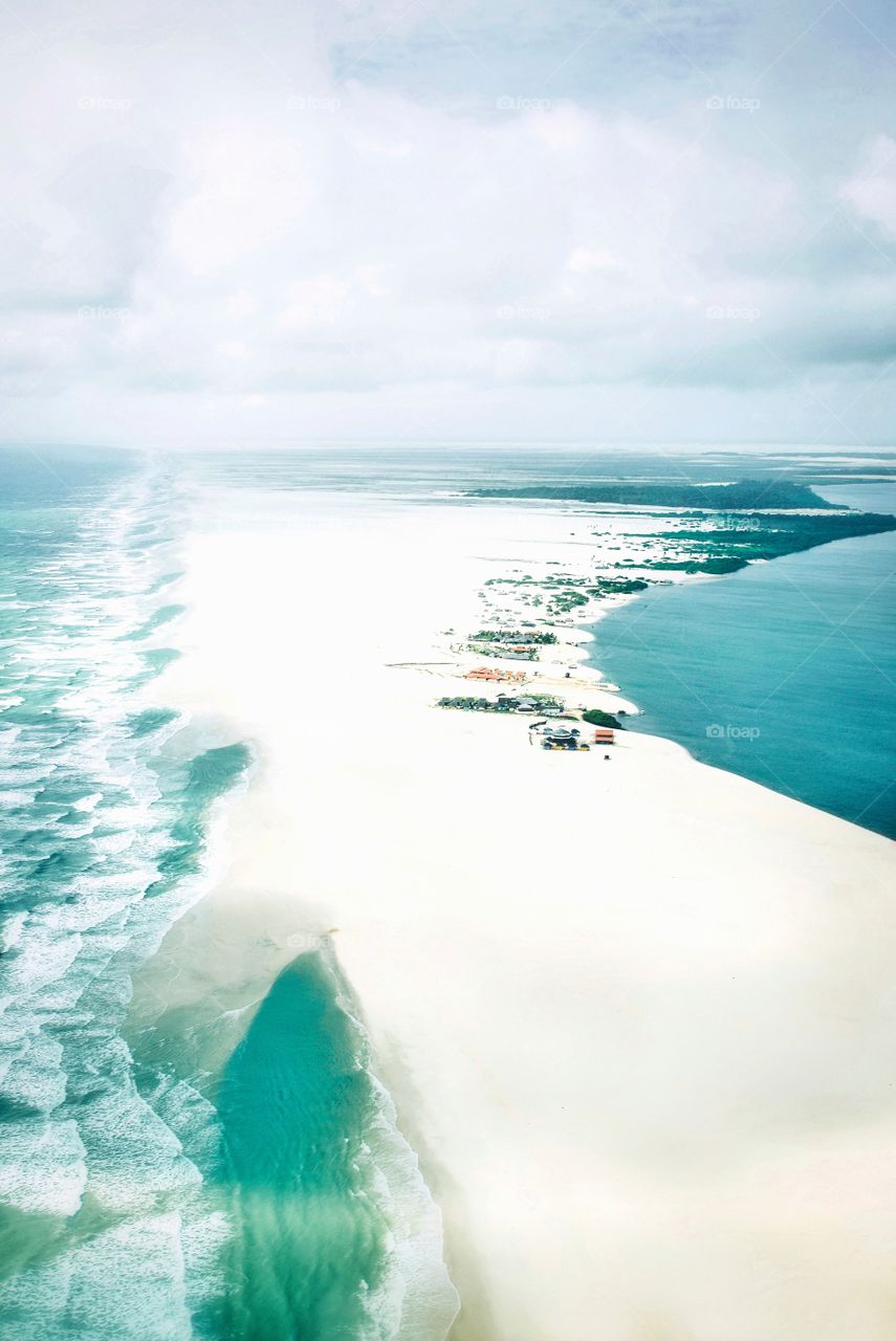 An island of white sand beaches between the ocean and the river