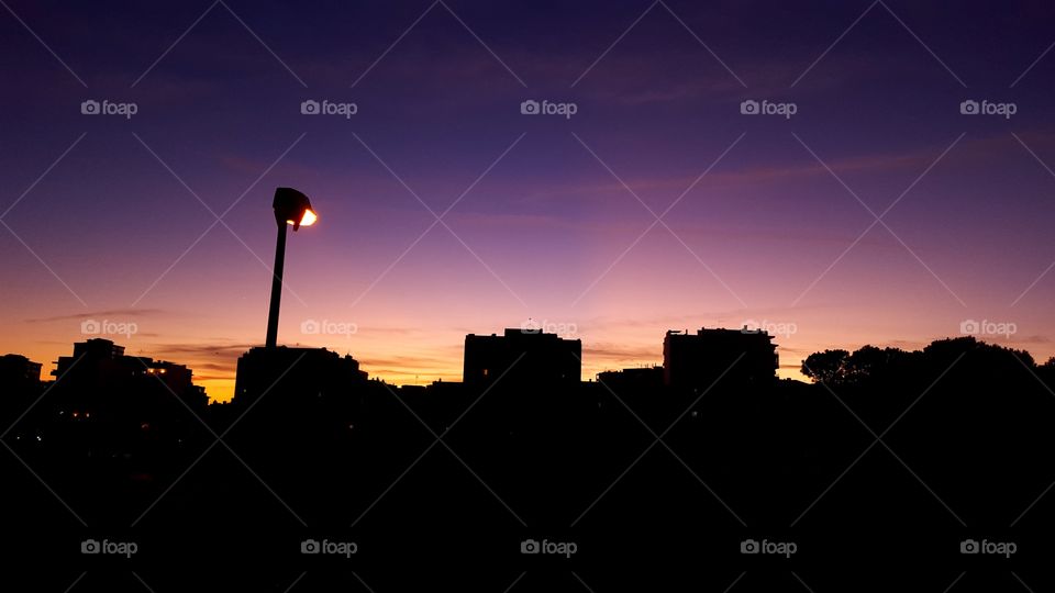 Silhouette of buildings with illuminated street light in the city