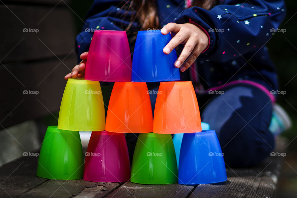 Child is playing with colorful plastic cups from ikea