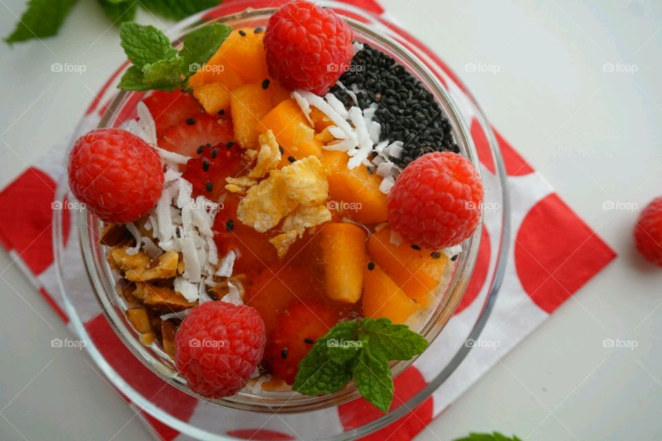 Smoothie fresh fruits bowl - peach, raspberry,  almonds,  strawberries,  coconut,  honey,  seeds and mints