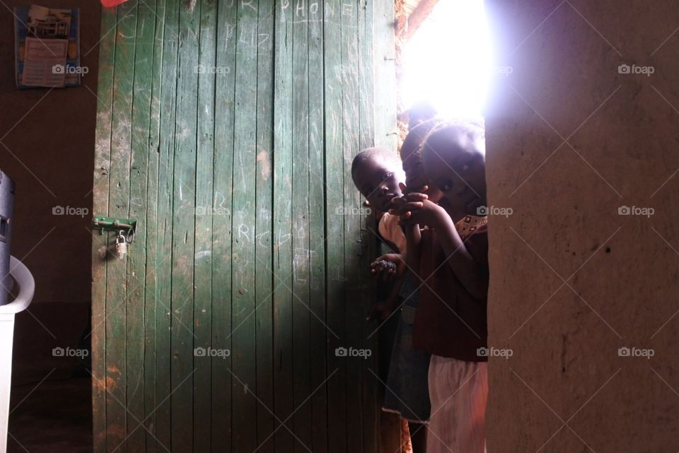 Peeking . Children peeking through a door 