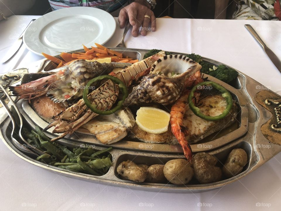 Portuguese style seafood platter with potatoes, vegetables and lemon