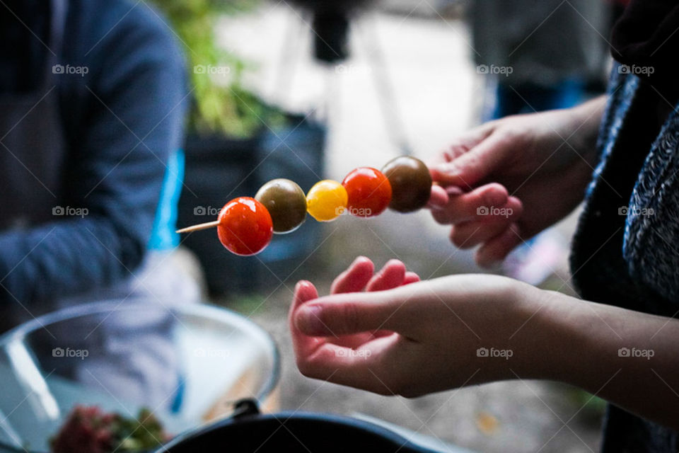 Person holding vegetables on skewer