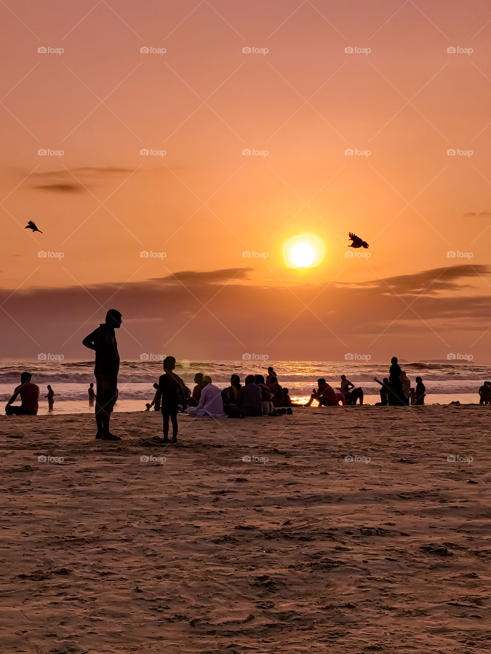 people on the beach watching the sun going down..🙂