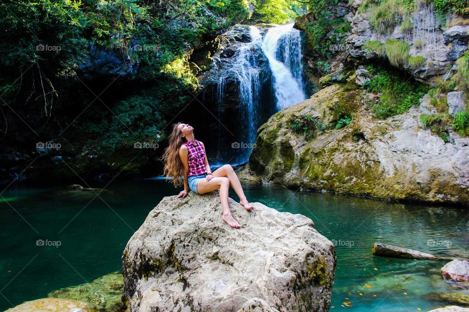 Girl sits on the rock.