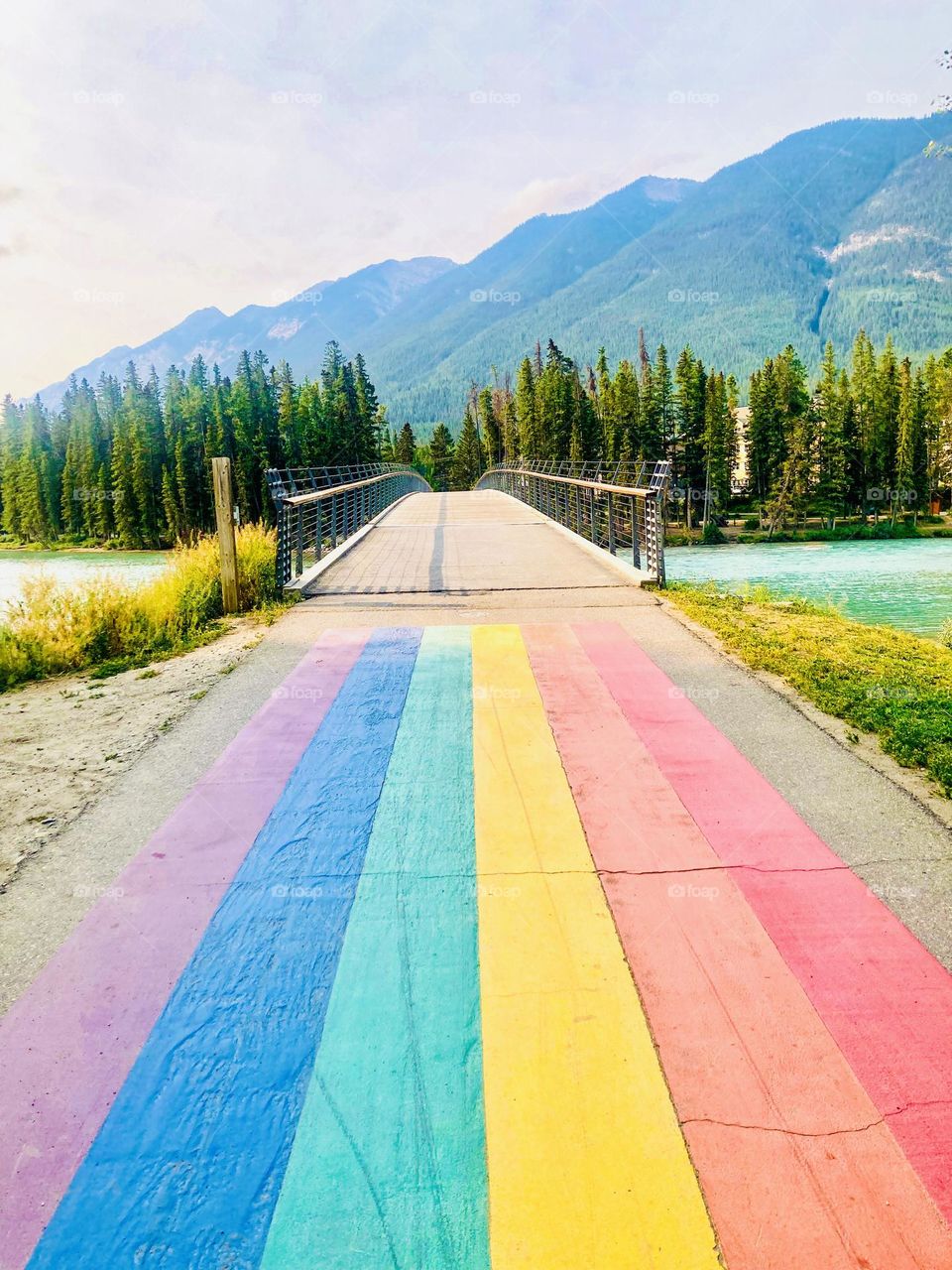 A rainbow flag in front of the Bow River footbridge in Banff, Alberta, Canada.