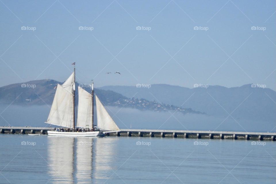 Sail boat with reflection on water