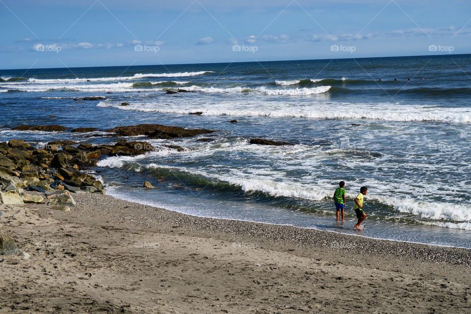 Ocean waves with  kids  on  beach 