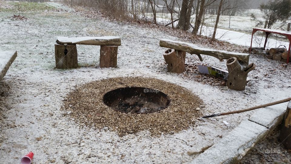 Dust of snow melted around fire pit, still warm from the night before.