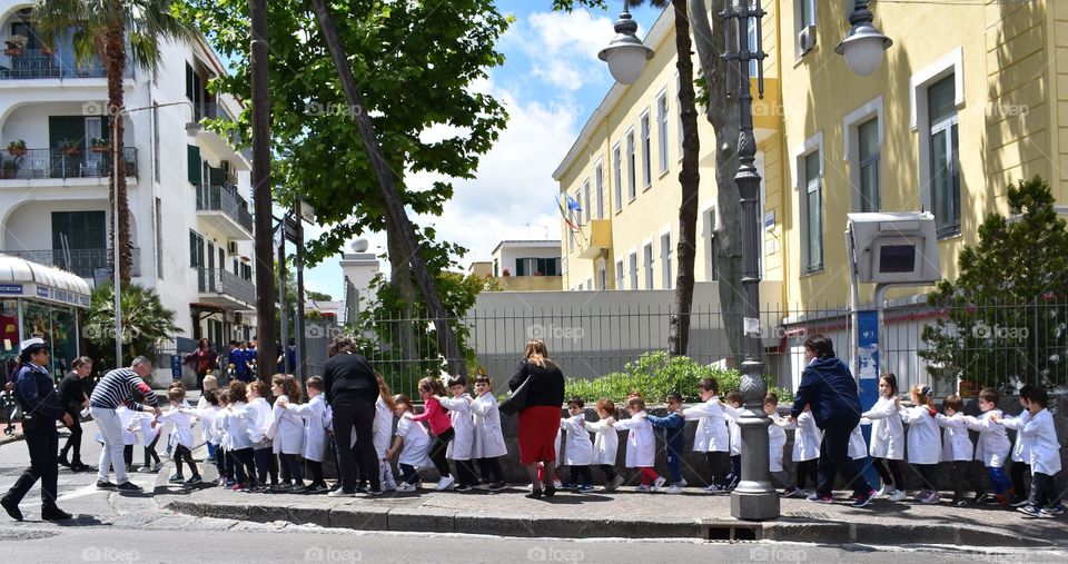 Children walking in line holding shirts 