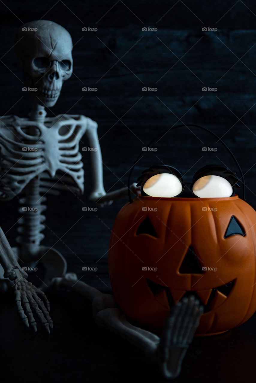 Glowing eyes Halloween decoration next to a skeleton 