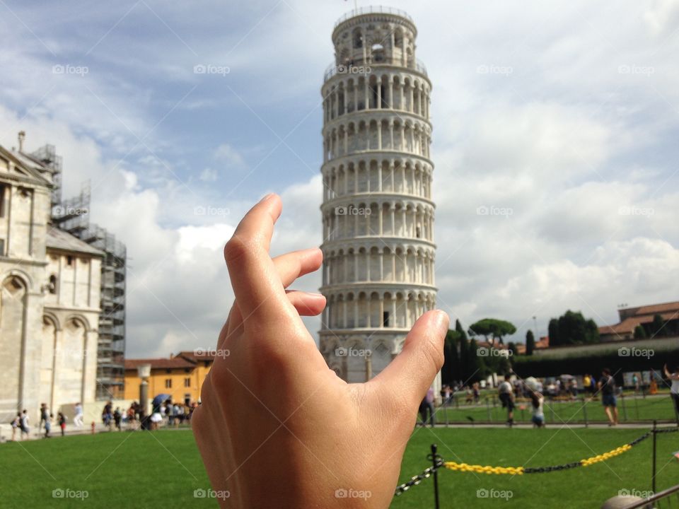 Hand holding Pisa tower 