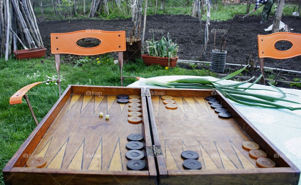 Playing a backgammon game at the backyard