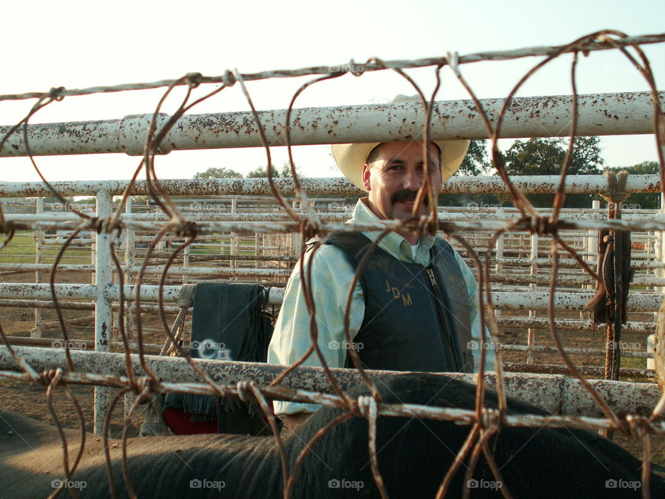 Man looking through metal fence