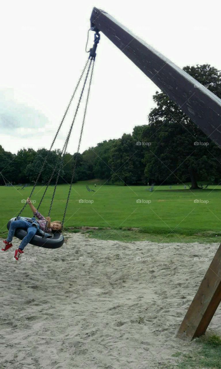 Boy enjoying swinging in park
