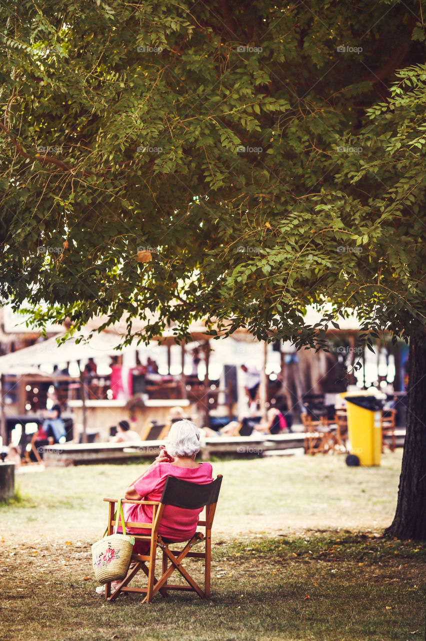 Elder woman enjoying beautiful sunny day in the shade