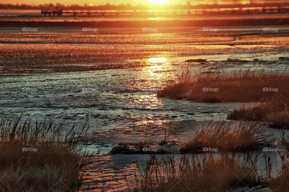 Sunrise on a cold winter day over the frozen North Sea beach