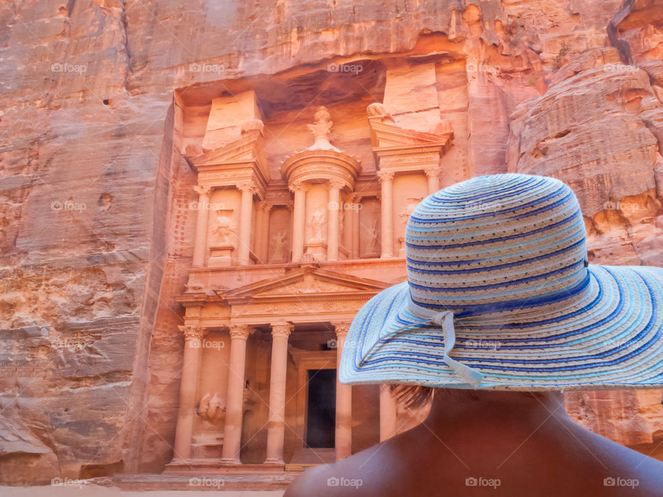 Woman in summer hat standing in front of the Treasury, Al Khazneh, in Lost City, Rose City, Petra. Jordan