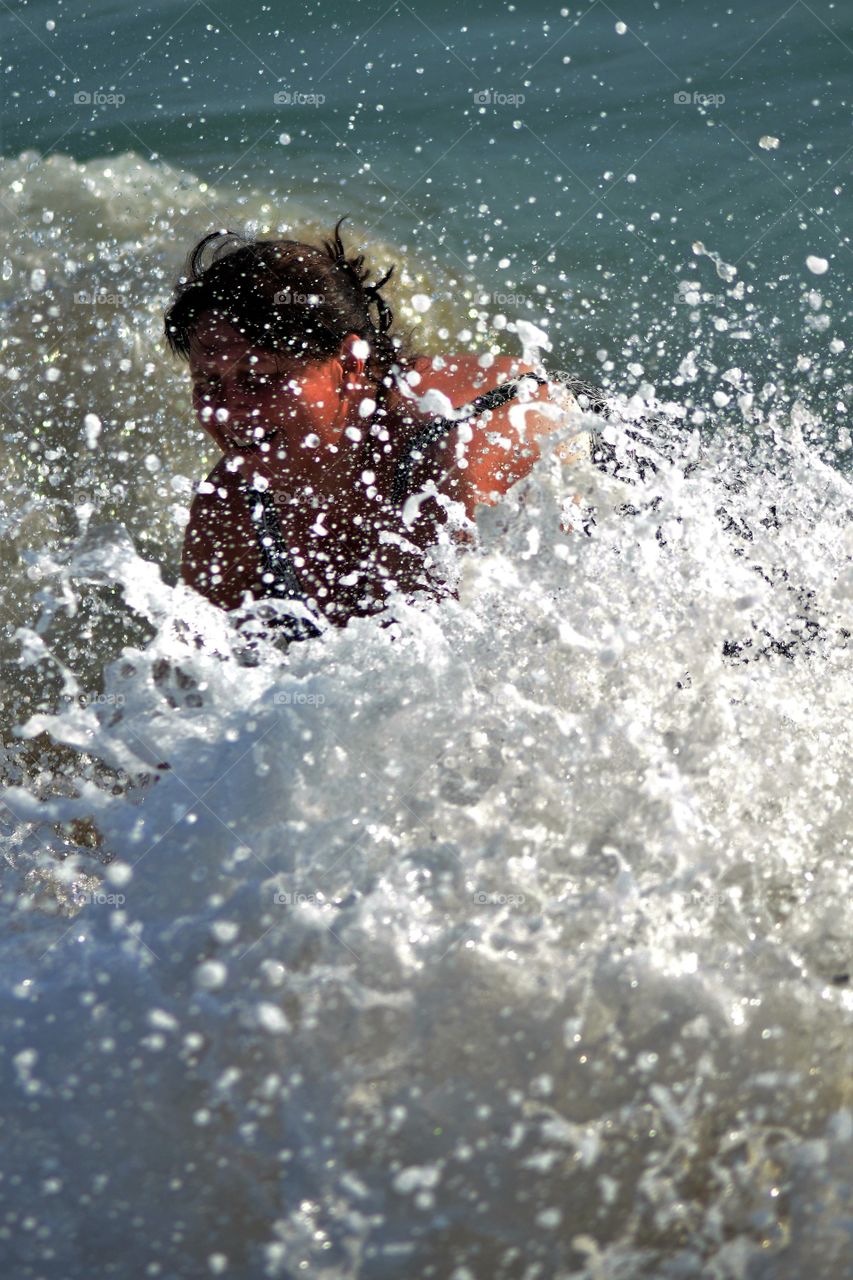 woman falling in wave.  Beach in Alanya turkey.