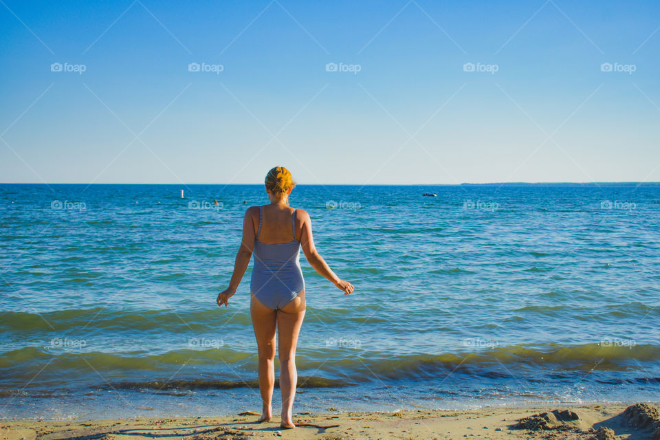 A Woman Standing In Front Of The Beach Water Ready To Go In
