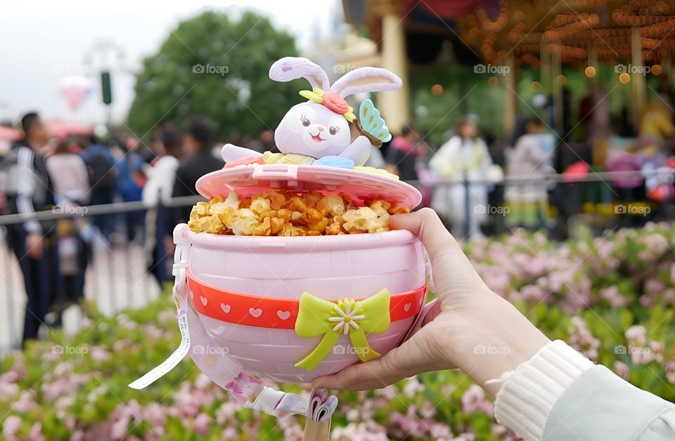 Rabbit cup with popcorn in the flower garden