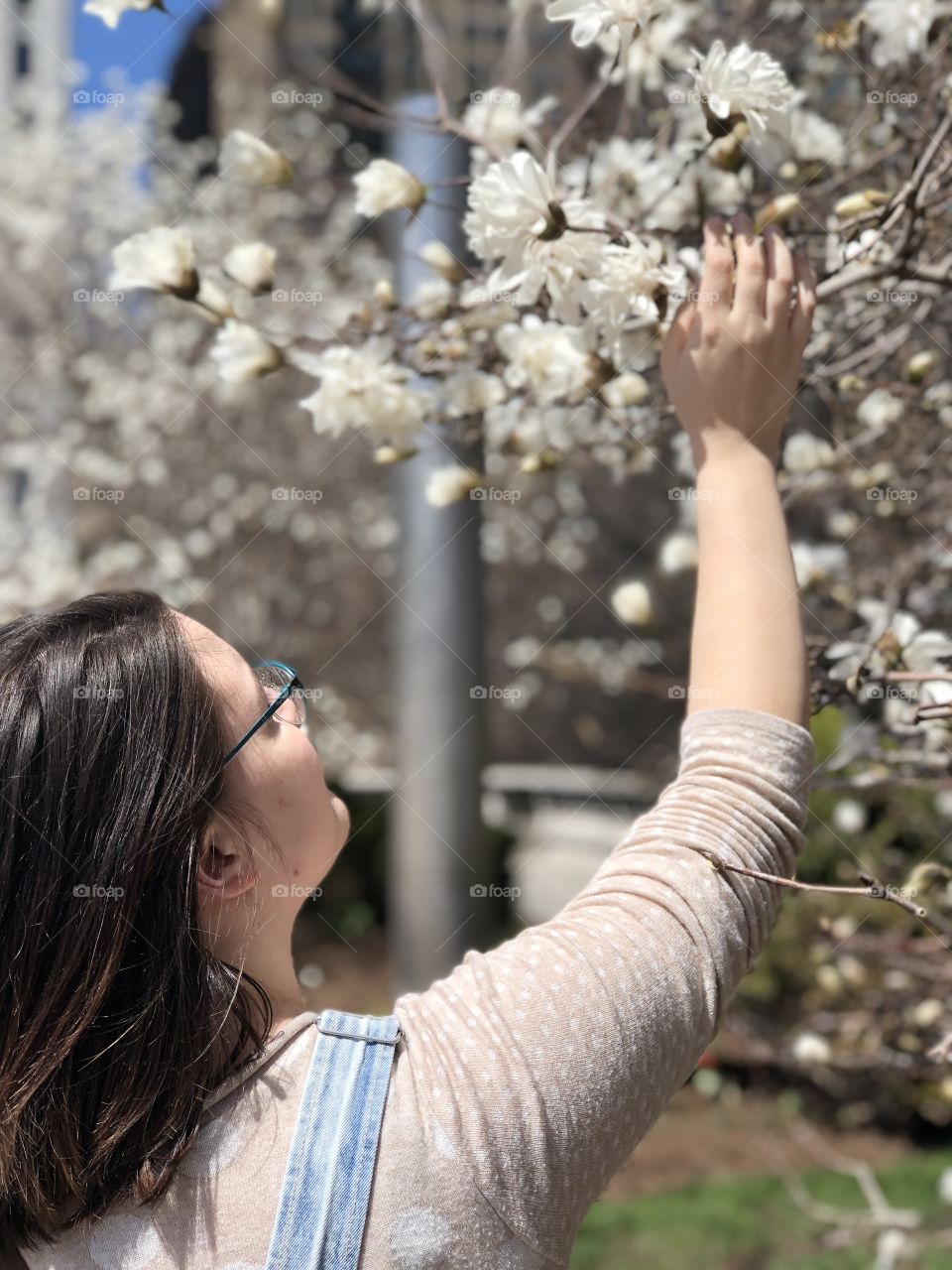 Girl reaching for the blossoming trees!
