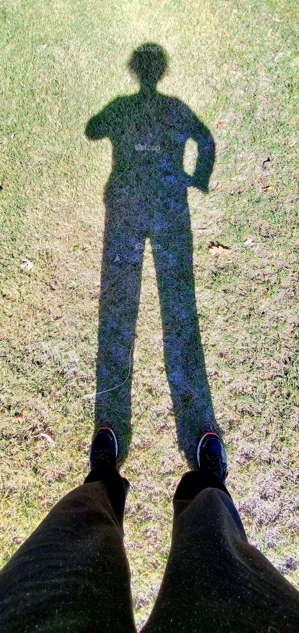 Shadow of person with arm on hip. LOL pic before going for walk,  with clothing for walking on. Shadow person!