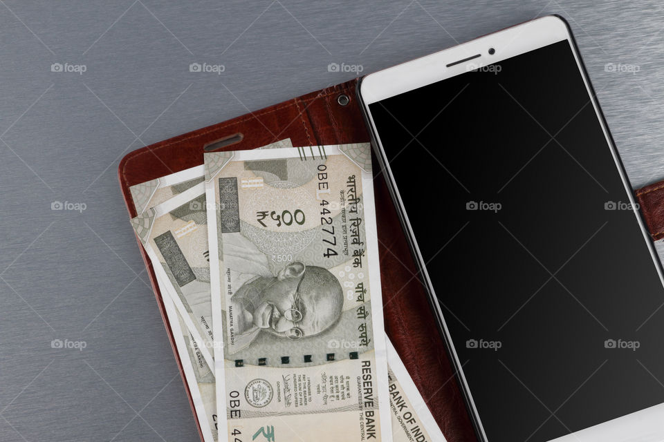 Indian money rupee currency with a mobile phone wallet