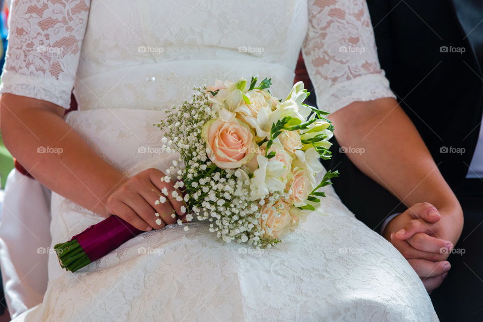 Close-up of bridal's hand holding bunch of flower