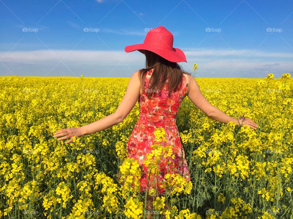 Rear view of women standing in flowers field