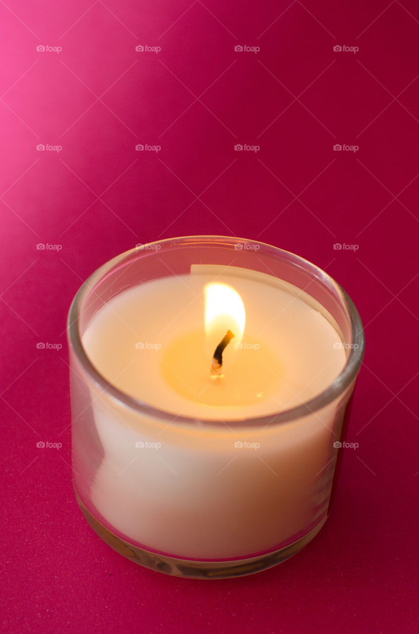 white candle on pink background