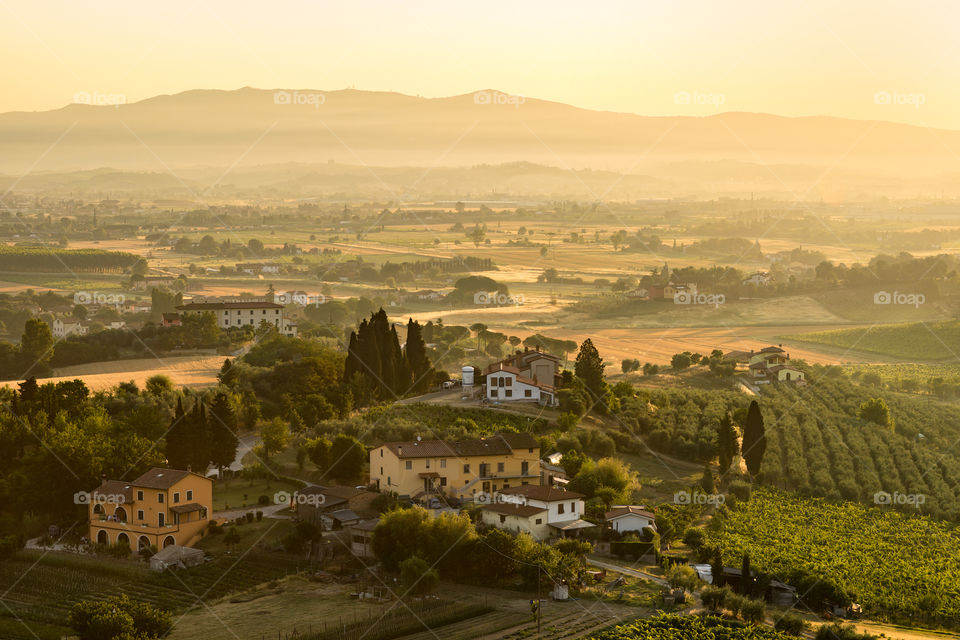 The first light of day on a small farmhouse in the hills of Tuscany