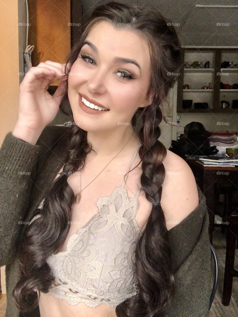 Brunette girl taking a selfie in her kitchen like a typical millennial. 